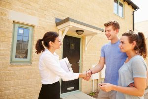 Real,Estate,Agent,Shaking,Hands,With,New,Property,Owners